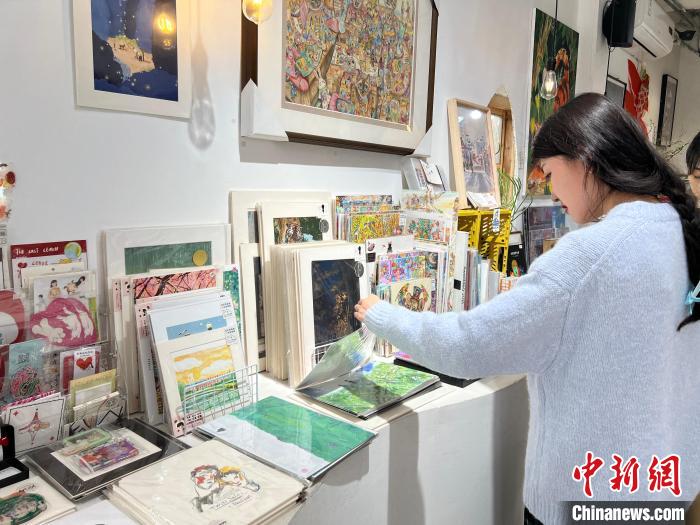 圖為藝術品商店內，顧客挑選插畫作品?！＄婌?攝