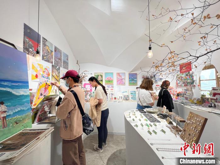 圖為藝術品商店內，顧客挑選插畫作品?！＄婌?攝