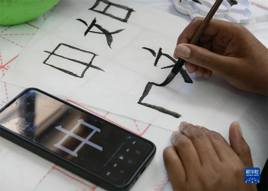 4月18日，肯尼亞學生在內(nèi)羅畢大學孔子學院舉辦的活動上寫毛筆字。肯尼亞內(nèi)羅畢大學孔子學院18日舉辦“中文，增進文明對話”主題活動，慶祝即將到來的第14個聯(lián)合國中文日。肯尼亞學生參與互動，進行書法、剪紙、唱中文歌等活動。新華社記者 韓旭 攝