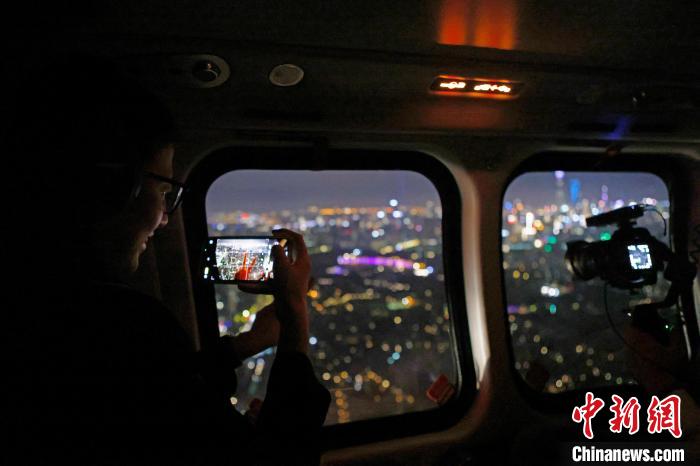 6月3日晚，游客乘坐上海新空直升機有限公司直升機開啟鳥瞰黃浦江空中圓夢之旅，并用手機拍攝城市夜景?！∫罅⑶?攝