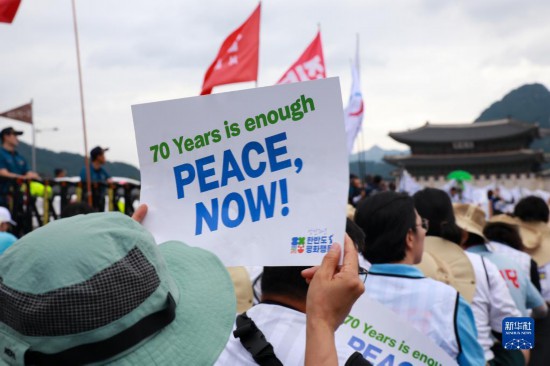 7月22日，在韓國首爾，人們手舉標語參與反戰游行。新華社發（楊暢 攝）