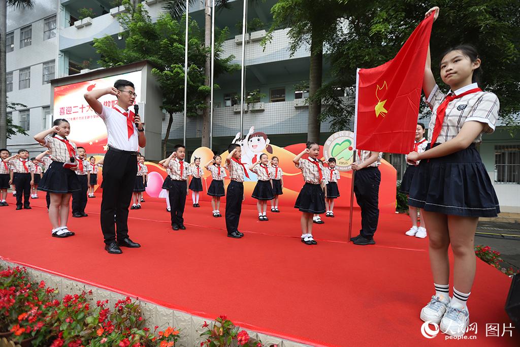 5月31日，在廣西壯族自治區(qū)南寧市民主路小學(xué)，學(xué)校大隊輔導(dǎo)員帶領(lǐng)少先隊員呼號。人民網(wǎng)記者 嚴(yán)立政攝