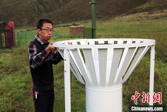圖為班瑪縣氣象局工作人員在維護藏雪茶基地氣候站。青海省氣象局供圖