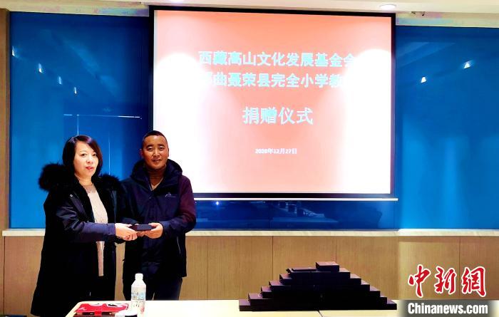 圖為西藏高山文化發(fā)展基金會(huì)理事長(zhǎng)溫麗向聶榮縣完全小學(xué)負(fù)責(zé)人捐助儀器。　于賓 攝