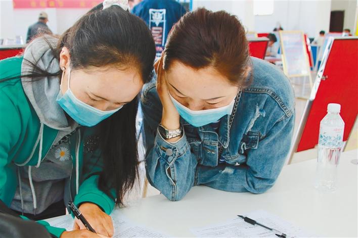 圖為應聘者在填寫報名表。記者 段敏 攝.jpg