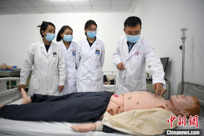 湖南中醫藥大學第一附屬醫院腦病科援藏醫生高曉峰(右一)為學生們進行體格檢查教學。　楊華峰 攝