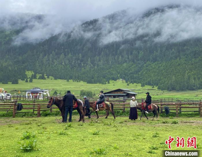 6月10日，游客在魯朗小鎮高山牧場景區體驗騎馬?！∪轿木?攝