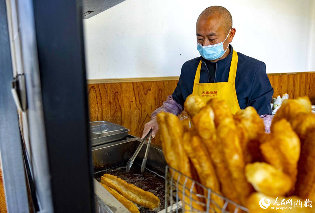 早餐店老板正在炸油條。人民網(wǎng) 次仁羅布攝